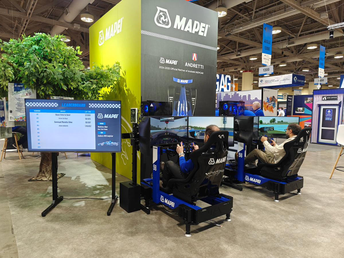 Guests race in blue MAPEI-branded ASR simulators beside a live leaderboard at a trade show.
